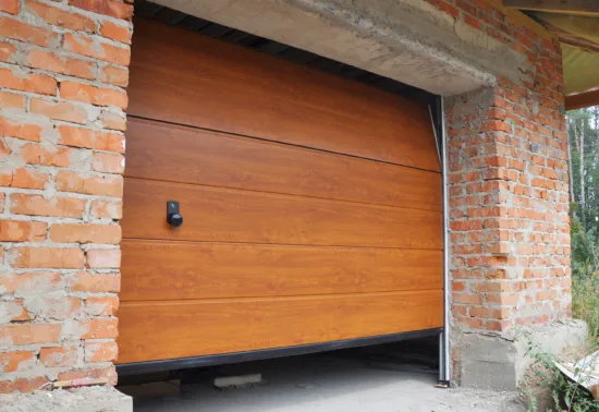 Why Is My Garage Door Not Opening Fully? AdobeStock 114904136 Partially open wooden garage door installed in a brick garage structure under construction, with some construction materials visible inside—a great example of quality Wisconsin garage door installation.