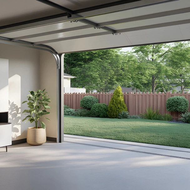 Services garage screen doors img Open garage with a potted plant inside leads to a well-maintained backyard featuring green grass, shrubs, trees, and a wooden fence—ideal for those seeking Illinois garage door repair under clear daylight.